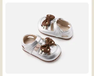 Detailed view of toddler girls' silver metallic shoes with a brown polka dot bow