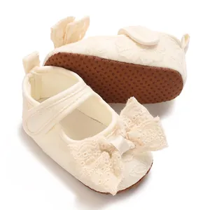 Close-up of baby girl princess shoes with delicate lace bow and anti-slip soft sole