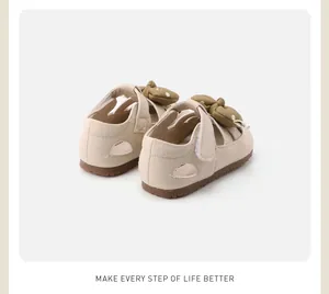 Rear view of cream toddler shoes with khaki bow and textured leather details.