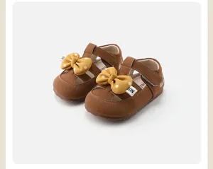Close-up of brown toddler girls shoes featuring yellow polka-dot bows and comfortable soft soles.