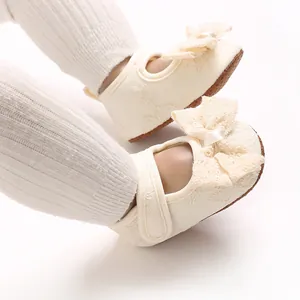 Close-up of cute baby girl princess shoes with decorative lace bow and soft sole