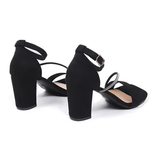 Close-up of black block heel sandals featuring sparkling rhinestone straps and buckle.