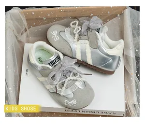 Detail showing silver girl's sneakers with elegant pearl and lace bow decorations