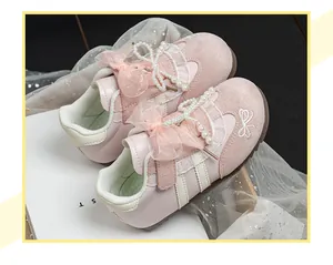 Close-up of pink girls' sneakers featuring elegant pearl and ribbon bow detailing.
