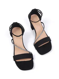 Detailed view of black chunky high heel sandals with sparkling rhinestone straps