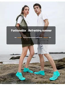Couple portant des chaussures d'eau turquoise à séchage rapide sur une plage.