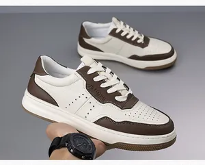 Dettaglio di sneaker da uomo in pelle traspirante color crema e marrone con spesse suole bianche.