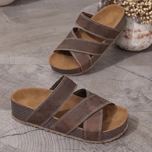 Detailed view of women's vintage brown platform sandals with cross straps and white stitching.