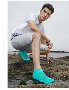 Mannequin masculin portant des chaussures d'eau turquoise sur plage rocheuse