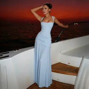 Model wearing an elegant light blue square neck pleated maxi dress on a luxury yacht at sunset
