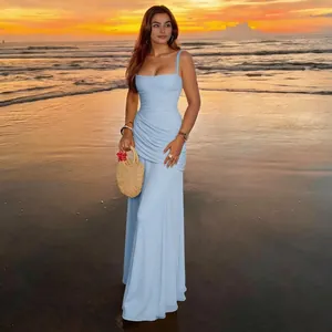 Elegant light blue ruched maxi dress with square neckline against a beach sunset.