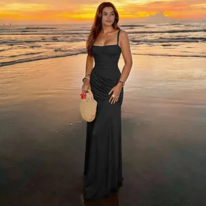 Elegant black square-neck ruched maxi dress worn by a model at a beach sunset.