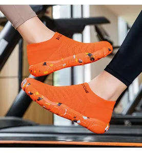 Macro view of orange breathable wading sock shoes with anti-slip pattern rubber sole.