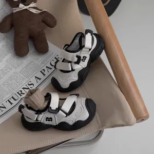 Close-up of children's black and white breathable sandals with anti-kick toe design