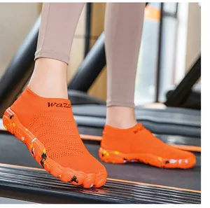 Close-up shot of orange barefoot fitness shoes worn on a treadmill for indoor training