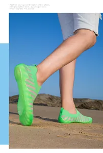 Close-up detailed view of neon green water shoes on a sandy beach for outdoor sports