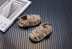 Nahaufnahme süßer brauner Babysandalen mit Bärendesign und weichen Antikick-Zehenkappen
