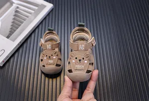 Detail niedlicher brauner Baby-Sandalen mit Bärenmuster und Klettverschluss