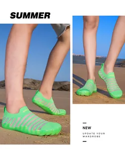 Close-up of breathable neon green barefoot water shoes on a sandy beach background