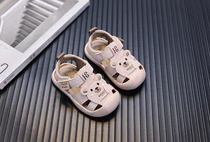 Nahaufnahme von rosa Kleinkindsandalen mit Bären-Design und weicher Schutzkappe