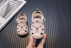 Nahaufnahme rosa Babysandalen mit süßem Bären-Design und weichen, schützenden Sohlen für Kinder.