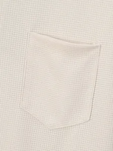 Macro detail van heren poloshirt met wafelstructuur en borstzak.