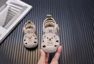 Nahaufnahme beiger Kleinkindsandalen mit süßem Bärendesign und schützender Zehenkappe