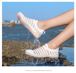 Detail view of breathable white water shoes splashing in ocean water for summer sports
