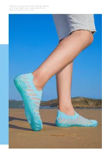 Close-up detail of light blue water wading shoes worn by a person on a sunny beach
