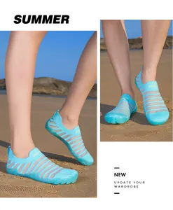 Detail view of breathable light blue beach shoes with striped pattern on sand