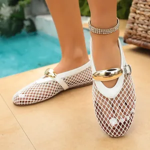 Gros plan de ballerines blanches en résille avec boucle métallique dorée