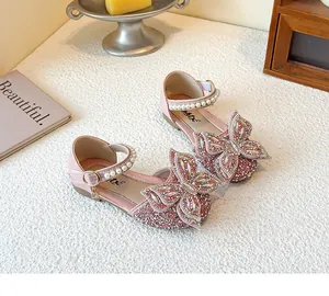 Nahaufnahme von rosa glitzernden Mädchenschuhen mit großer Strass-Schleife.