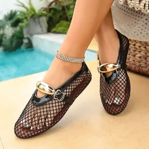 Détail de ballerines noires en résille avec boucles dorées dans un décor estival.