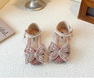 Detailansicht rosa glitzernder Mädchenschuhe mit einer großen Schmetterling aus Strass