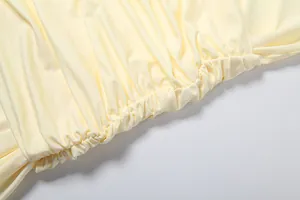 High-quality close-up showing the gathered elastic waist detail on a light yellow dress