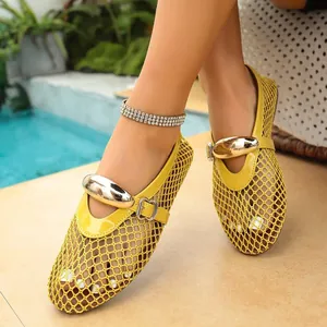 Gros plan sur des ballerines Mary Jane en maille jaune avec boucle dorée géante