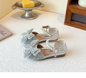 Detailansicht glitzernder silberner Mädchensandalen mit Schmetterling-Strasssteinen