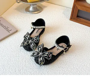 Detail von glitzernden Mädchen-Prinzessin-Schuhen mit Strass-Schmetterling und Perlen.