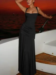 Elegant black square neck maxi dress with ruched waist on a yacht sunset background