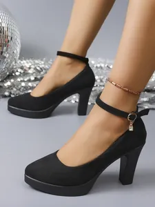 Close-up detail of stylish black suede chunky heel pumps with ankle strap and platform