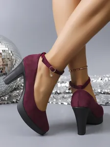 Detailed view of wine red suede chunky heel pumps featuring an ankle strap with crystal charm