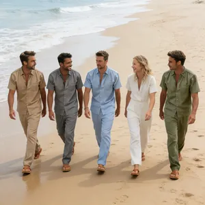 Group wearing matching linen shirt and trousers sets walking along a sunny summer beach