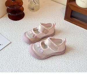 Detail von rosa Netzschuhen für Mädchen mit süßer Schleifenstickerei und Rüschenriemen