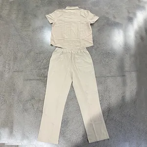 Full flat lay presentation of a beige men's linen short sleeve shirt and matching trousers set