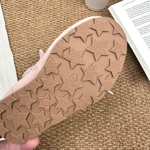 Close-up of pinkish-tan girl's shoe sole with non-slip star pattern texture