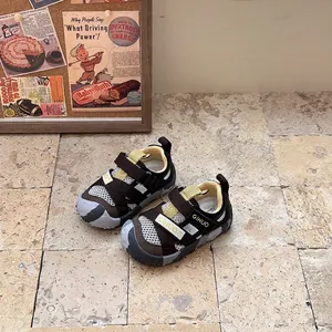 Detail view of children's closed-toe athletic sandals on stone floor.