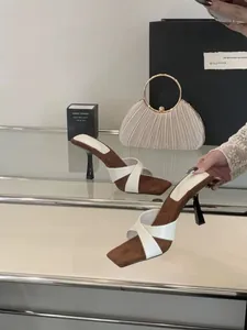 Κομψά mules με τετράγωνη μύτη, λεπτό τακούνι και λευκά χιαστί λουράκια σε λεπτομέρεια