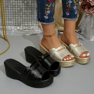 Dettaglio sandali con zeppa da donna con trama coccodrillo in nero e oro elegante