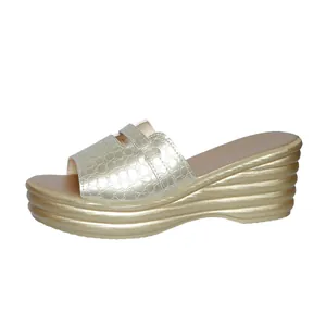 Sandalo con zeppa oro champagne, trama coccodrillo e suola platform ondulata.