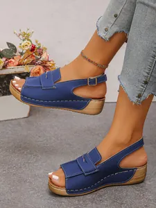 Eleganti sandali con zeppa blu a punta aperta con cinturino regolabile su modella